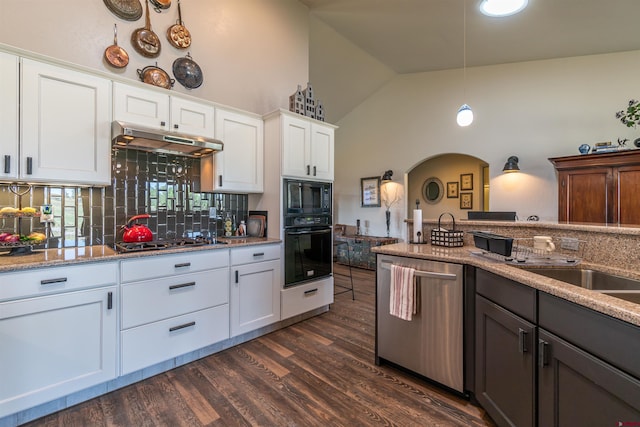 kitchen with arched walkways, decorative backsplash, dark wood-type flooring, under cabinet range hood, and black appliances