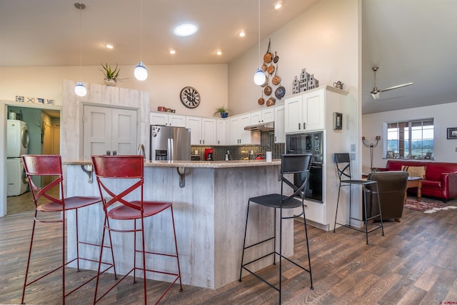 kitchen featuring a breakfast bar, white cabinets, high vaulted ceiling, under cabinet range hood, and black appliances