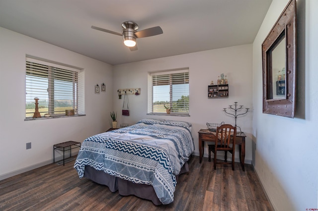 bedroom featuring multiple windows, baseboards, and wood finished floors