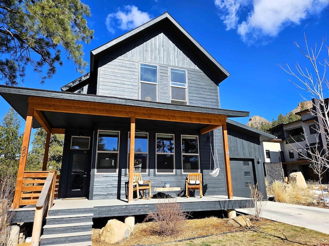 view of front of property with concrete driveway, a porch, and an attached garage