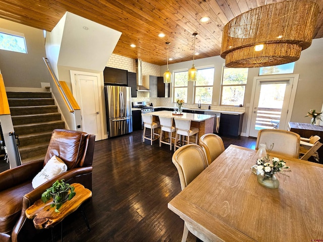 dining area featuring stairs, a wealth of natural light, dark wood-style floors, and wood ceiling