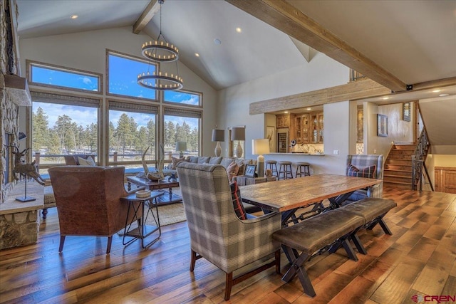 dining space featuring a chandelier, wood-type flooring, beamed ceiling, and high vaulted ceiling