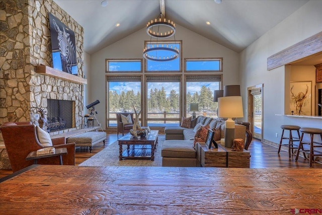 living room featuring a fireplace, an inviting chandelier, wood finished floors, high vaulted ceiling, and baseboards