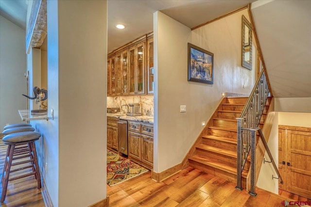 staircase featuring recessed lighting, baseboards, and wood finished floors