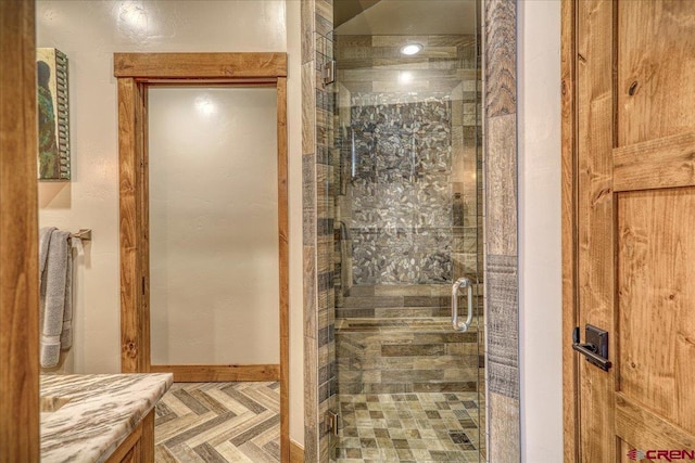 full bathroom with a shower stall and baseboards