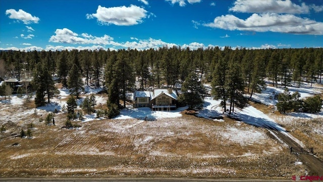 snowy aerial view featuring a view of trees