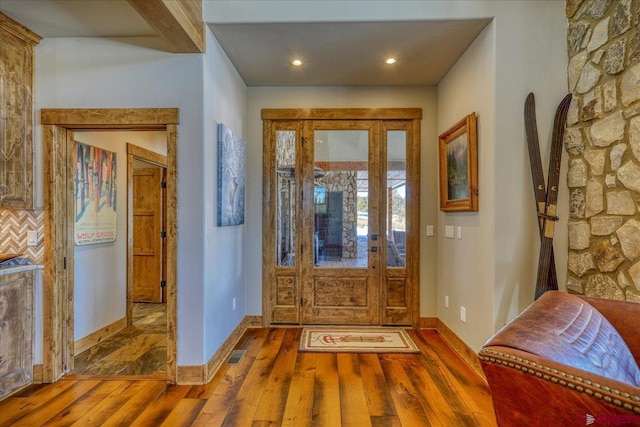 entryway with wood-type flooring, visible vents, baseboards, and recessed lighting