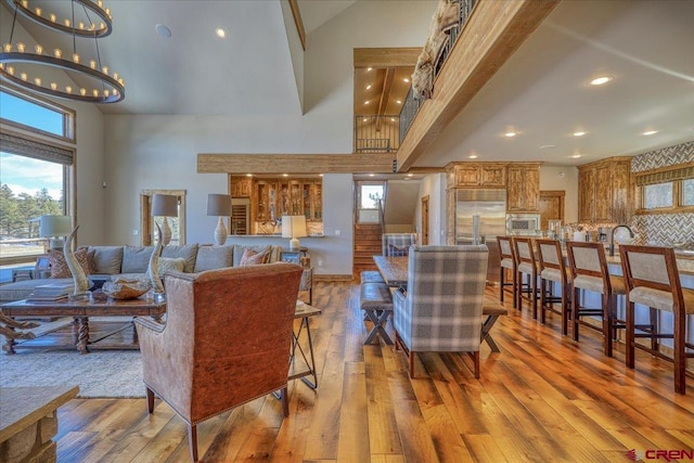 living area featuring a high ceiling, wood-type flooring, and recessed lighting