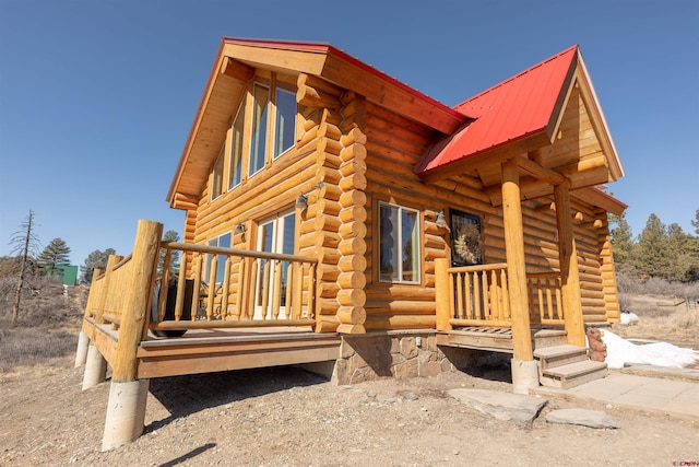 view of property exterior with metal roof and log siding