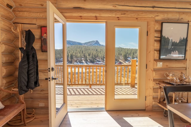 doorway to outside featuring rustic walls, french doors, wood-type flooring, and a mountain view