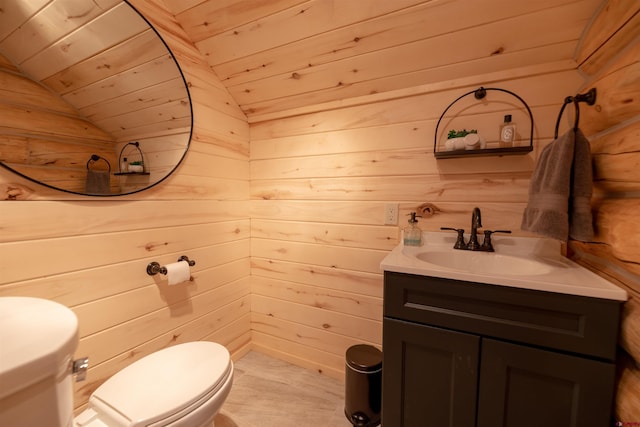 bathroom with toilet, wooden walls, and vaulted ceiling