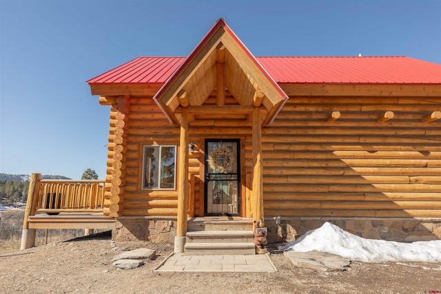 entrance to property featuring metal roof and log siding