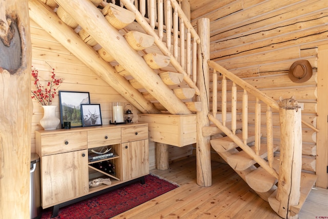 unfurnished bedroom featuring vaulted ceiling, rustic walls, and light wood-style floors