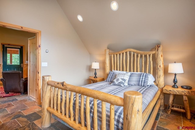 bedroom with vaulted ceiling and stone tile flooring