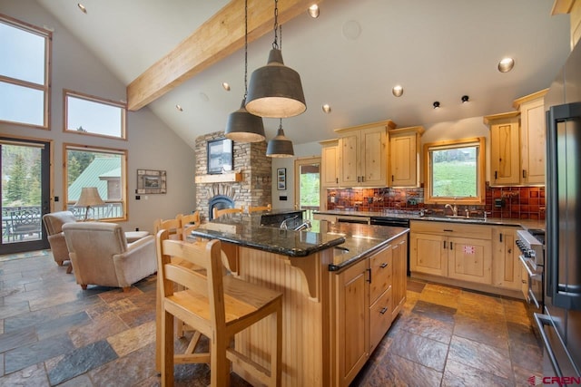 kitchen featuring stone tile flooring, a stone fireplace, open floor plan, and light brown cabinetry