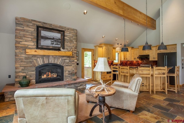 living area featuring high vaulted ceiling, beam ceiling, a fireplace, and stone tile flooring