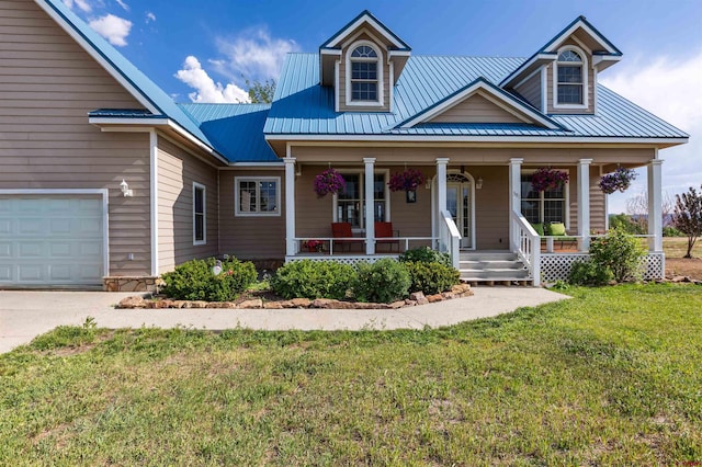 view of front facade featuring a garage, covered porch, metal roof, and a front yard