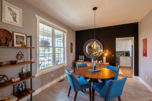 dining room featuring baseboards, wine cooler, and visible vents