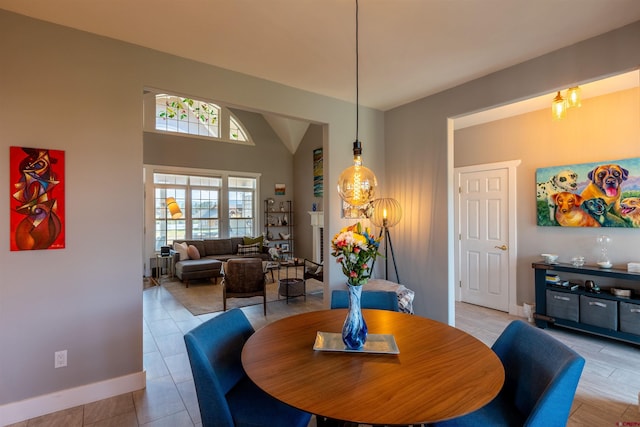 dining area featuring lofted ceiling and baseboards