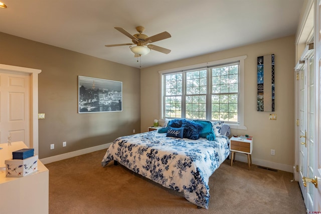 carpeted bedroom with visible vents, ceiling fan, and baseboards