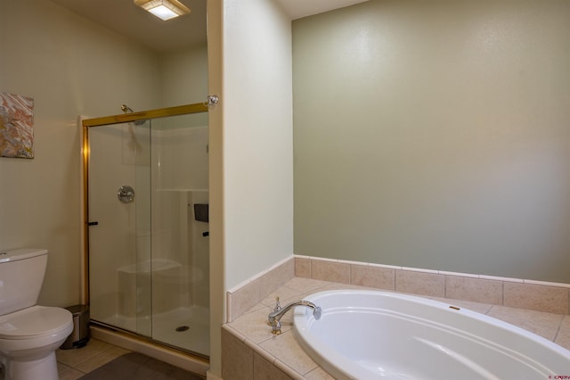 bathroom featuring a garden tub, a shower stall, toilet, and tile patterned floors