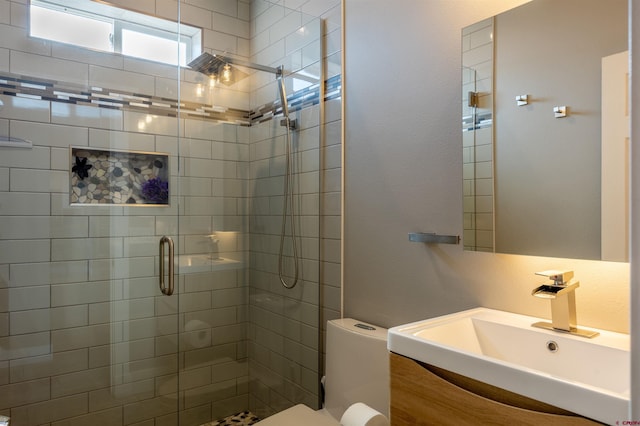 bathroom with a stall shower, vanity, and toilet