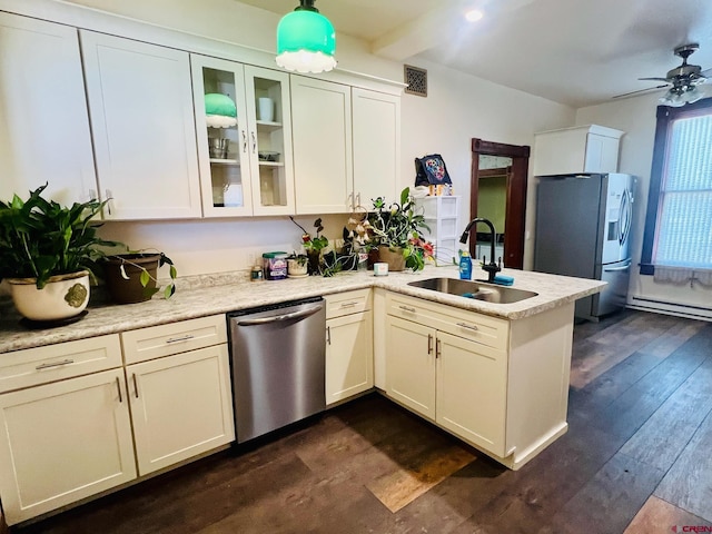 kitchen featuring stainless steel appliances, visible vents, dark wood-type flooring, a sink, and a peninsula