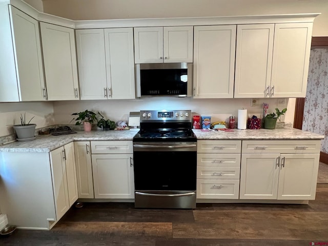 kitchen with appliances with stainless steel finishes, white cabinets, light countertops, and dark wood finished floors