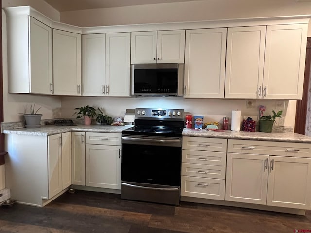 kitchen featuring appliances with stainless steel finishes, dark wood-style flooring, light countertops, and white cabinetry