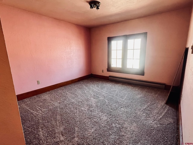 spare room featuring carpet, a textured wall, a baseboard radiator, and baseboards