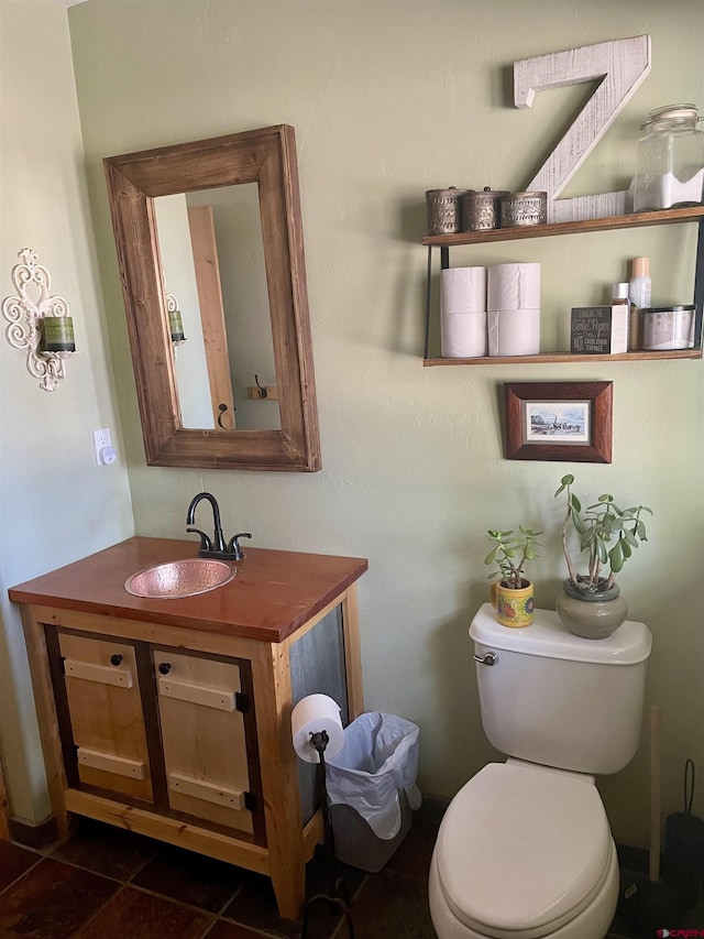 half bath featuring vanity, toilet, and tile patterned floors