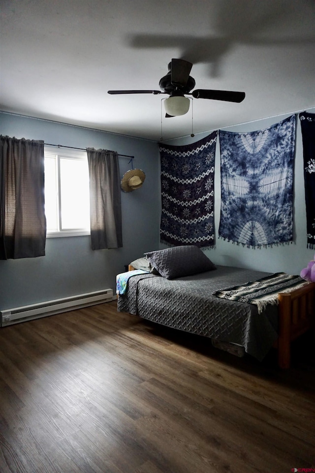 bedroom with a baseboard radiator, wood finished floors, and a ceiling fan