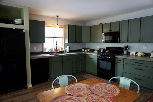 kitchen with black appliances, hanging light fixtures, dark wood-style flooring, and green cabinetry