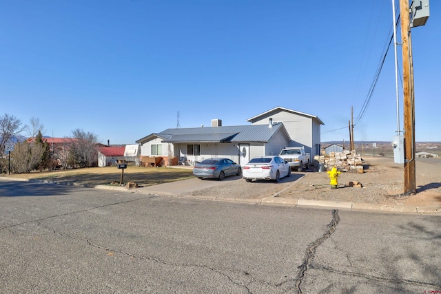 view of front of property featuring driveway and metal roof