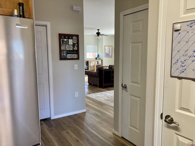 corridor with dark wood finished floors and baseboards