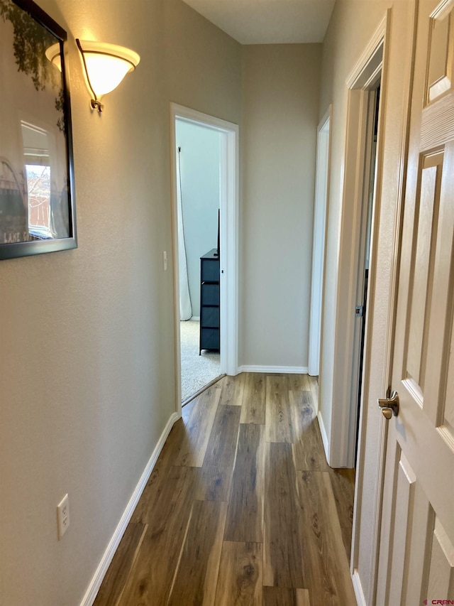 hall with wood finished floors and baseboards