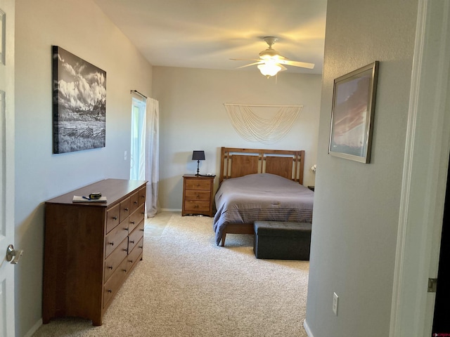 bedroom with a ceiling fan, light colored carpet, and baseboards