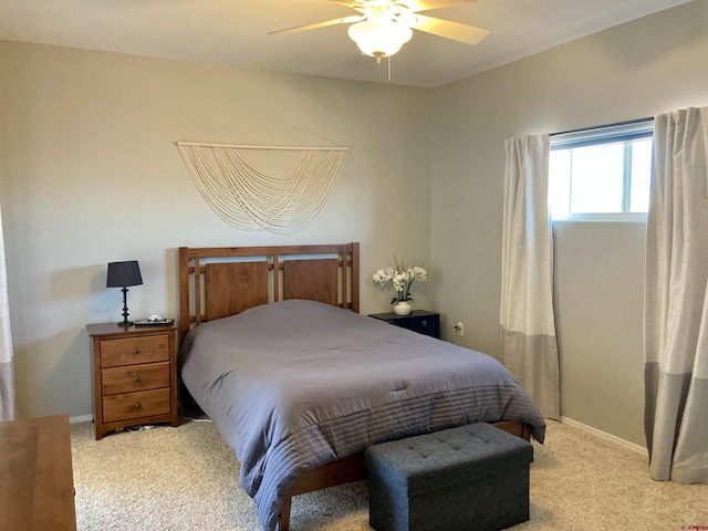 bedroom featuring light carpet, ceiling fan, and baseboards