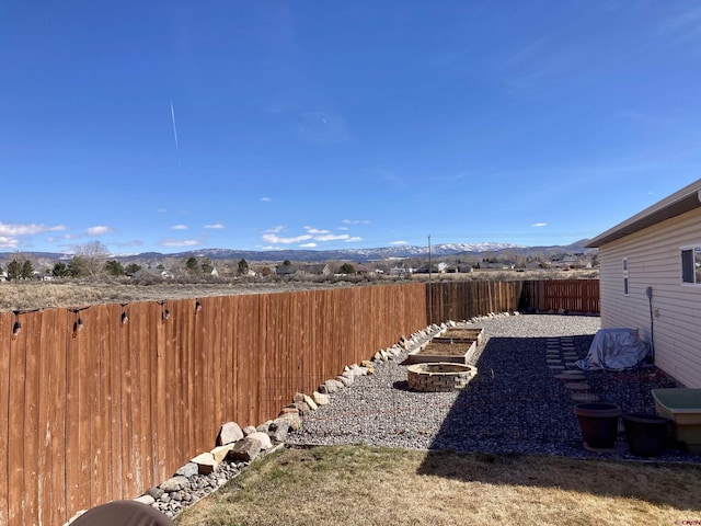 view of yard featuring a fenced backyard and a mountain view