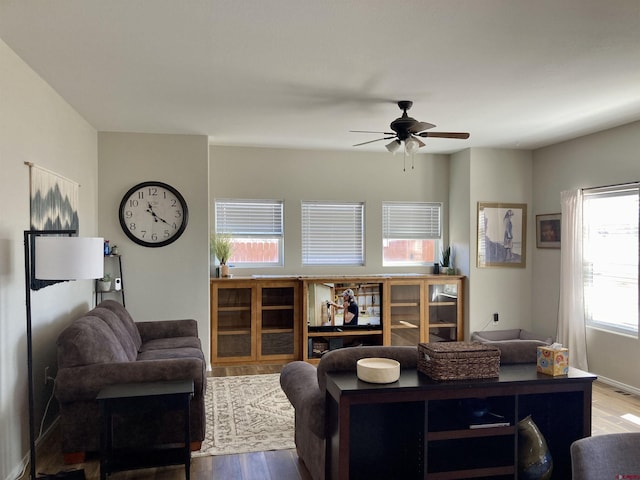 living area with ceiling fan and wood finished floors