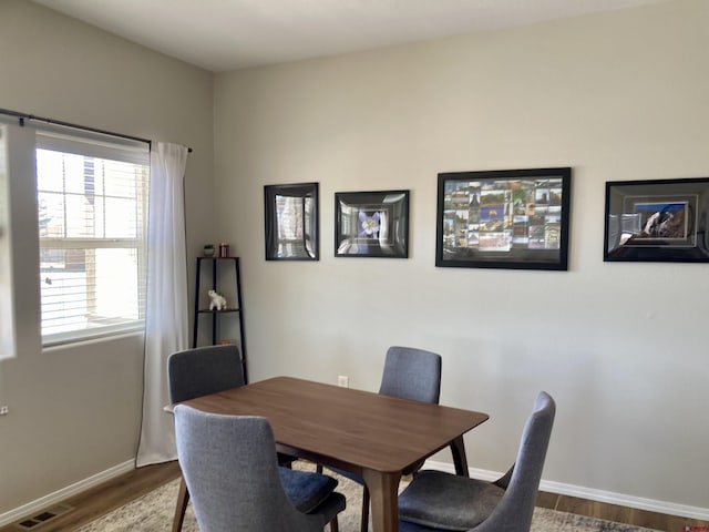 dining room with baseboards, visible vents, and wood finished floors