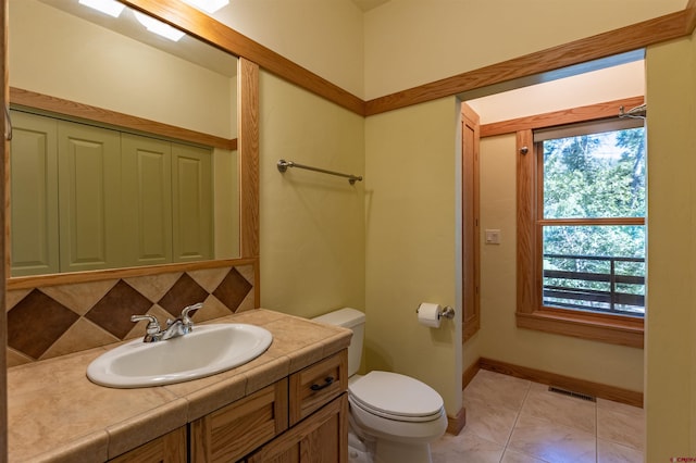 bathroom with tile patterned flooring, toilet, vanity, visible vents, and backsplash