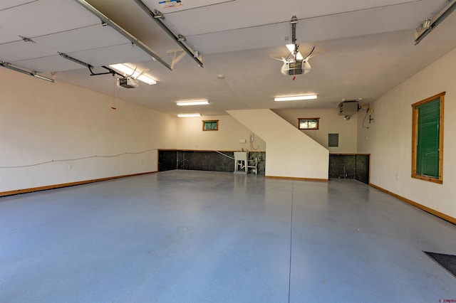 garage featuring electric panel, baseboards, and a garage door opener