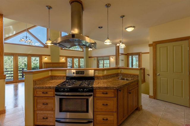 kitchen with dark countertops, island range hood, a sink, and gas stove