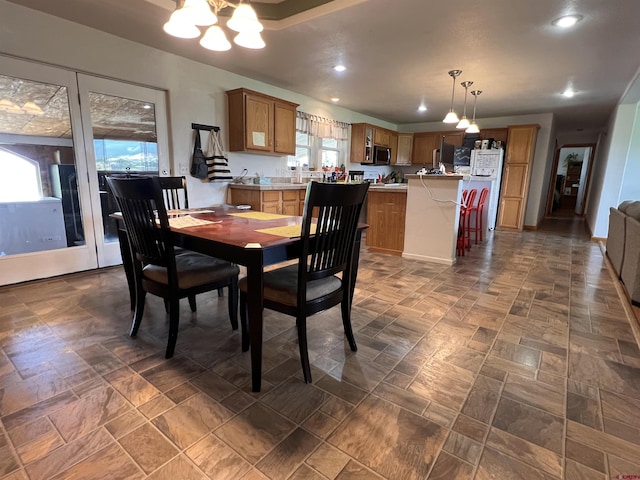 dining room featuring stone finish floor, recessed lighting, and a chandelier