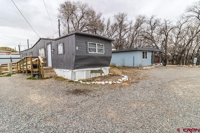 view of front facade with gravel driveway and fence