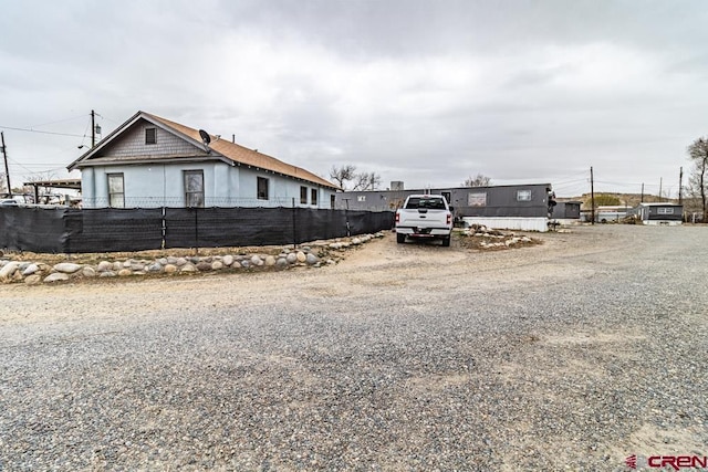 view of side of property featuring fence and driveway