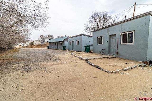 back of property featuring stucco siding and driveway