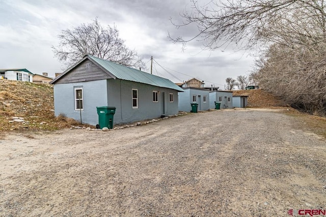 exterior space with metal roof and driveway