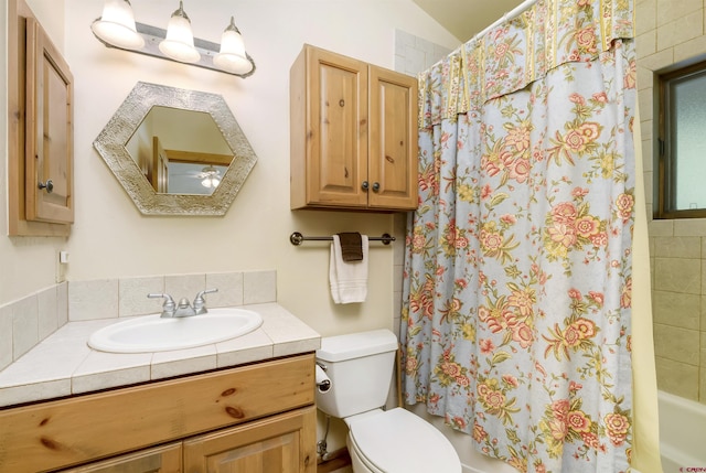 bathroom featuring shower / bath combination with curtain, toilet, and vanity